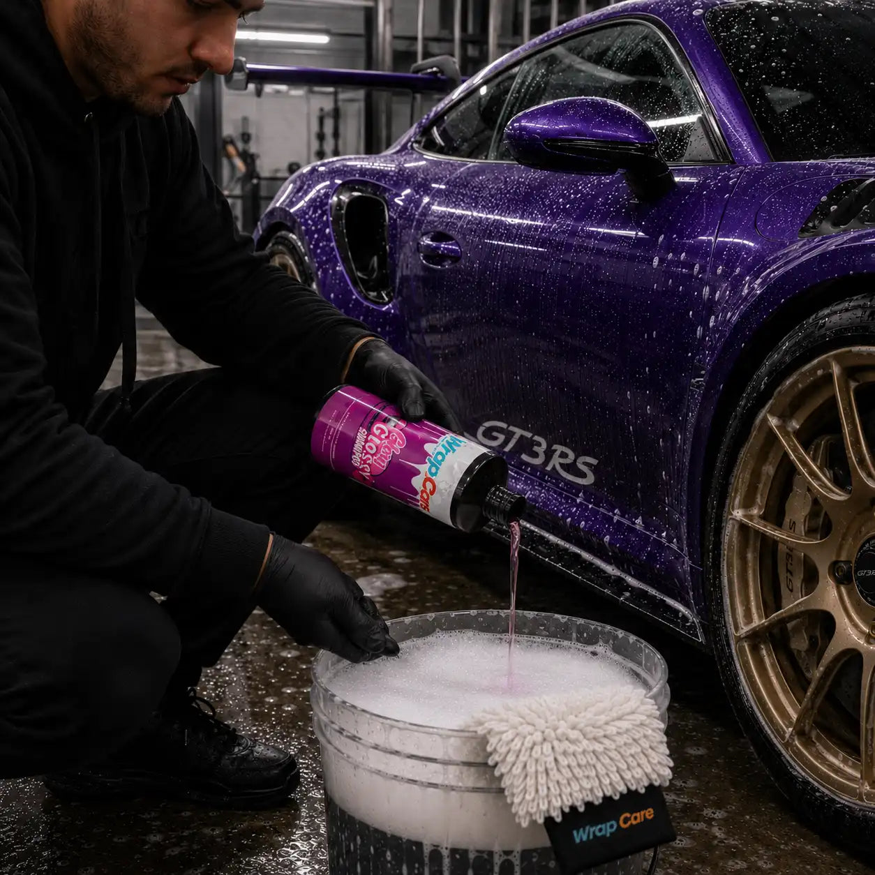 WrapCare Shampoo Glory Glossy wird in einen Wascheimer eingefüllt. Dahinter steht ein Porsche GT3RS